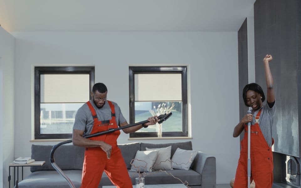 Commercial cleaning crew with vacuum and mop in a client workspace