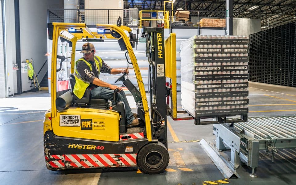 Forklift operator moving a pallet on a warehouse loading dock